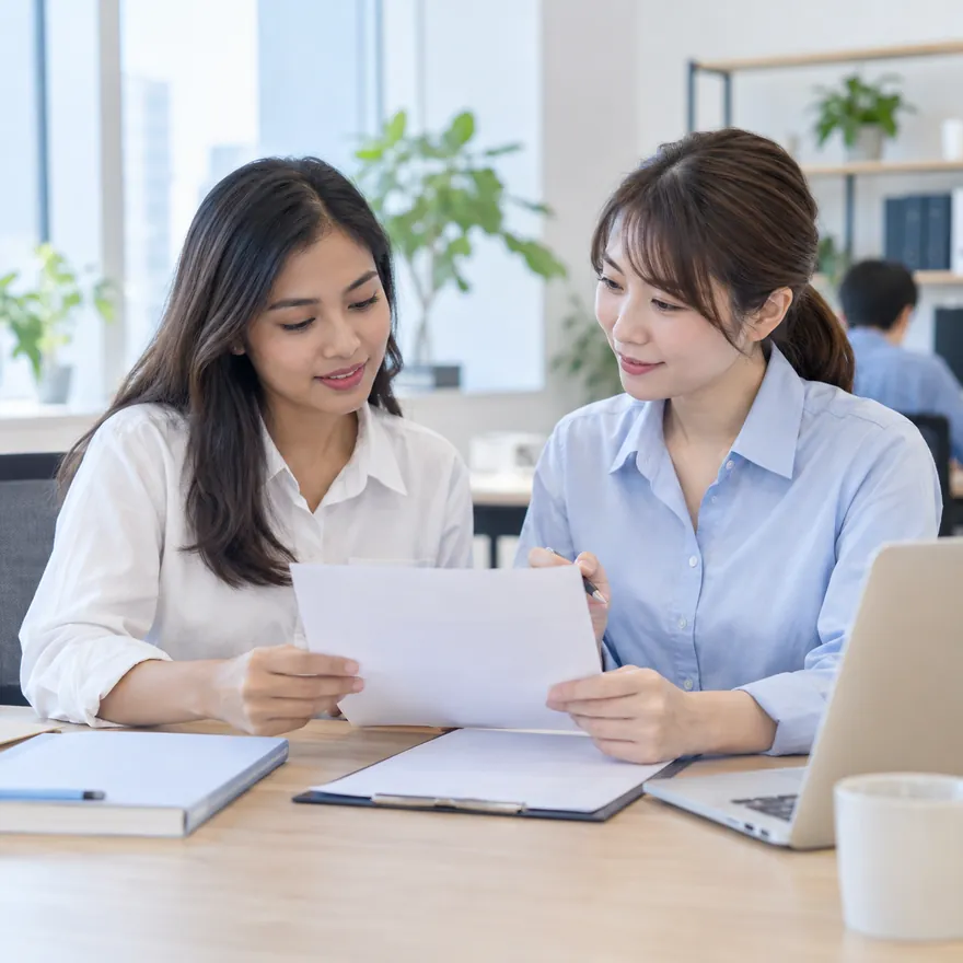 外国人スタッフと人事担当者が書類を確認する様子